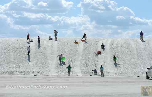Picture of children sledding on the dunes at White Sands National Monument